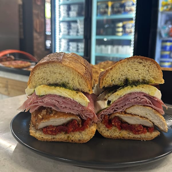Two halves of a Gabagool Italian sandwich, filled with meats, cheese, and sun-dried tomatoes.