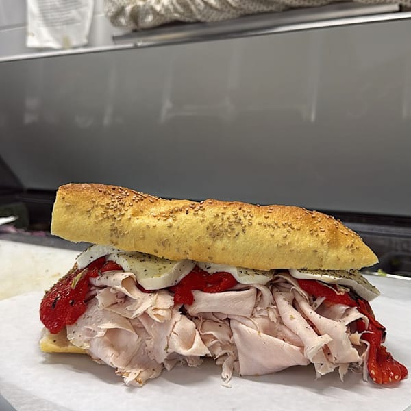 A Gabagool Italian sandwich with sliced turkey, roasted red peppers, and mozzarella cheese.